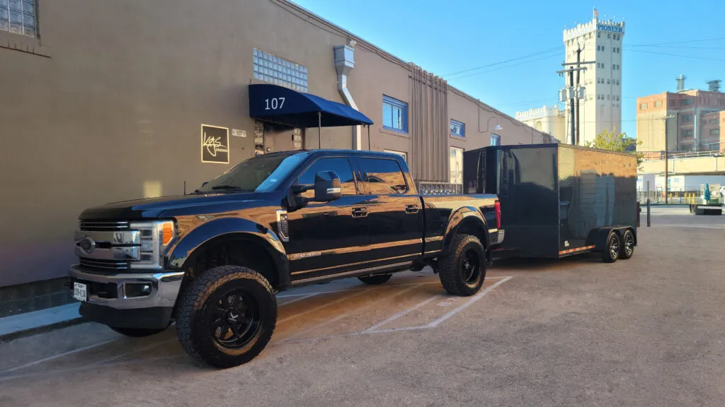 KGS Studios custom black art transport trailer and truck parked outside the studio entrance at Blue Star Arts Complex, ready for personal white-glove delivery.