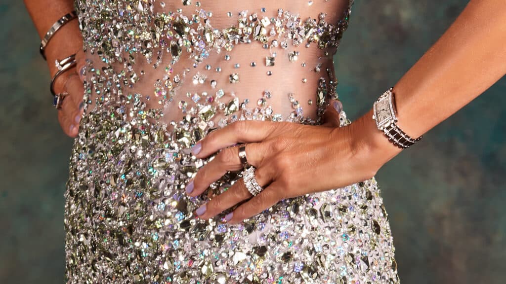 Extreme close-up detail of the hand-beaded gown and jewelry from Madame Tex, showing intricate craftsmanship, light play, and crisp physical texture — proof that grand-scale portraits cannot be replicated by artificial intelligence.