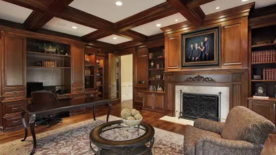 KGS Studios family legacy portrait hanging above the fireplace in a classic, wood-paneled library and study.