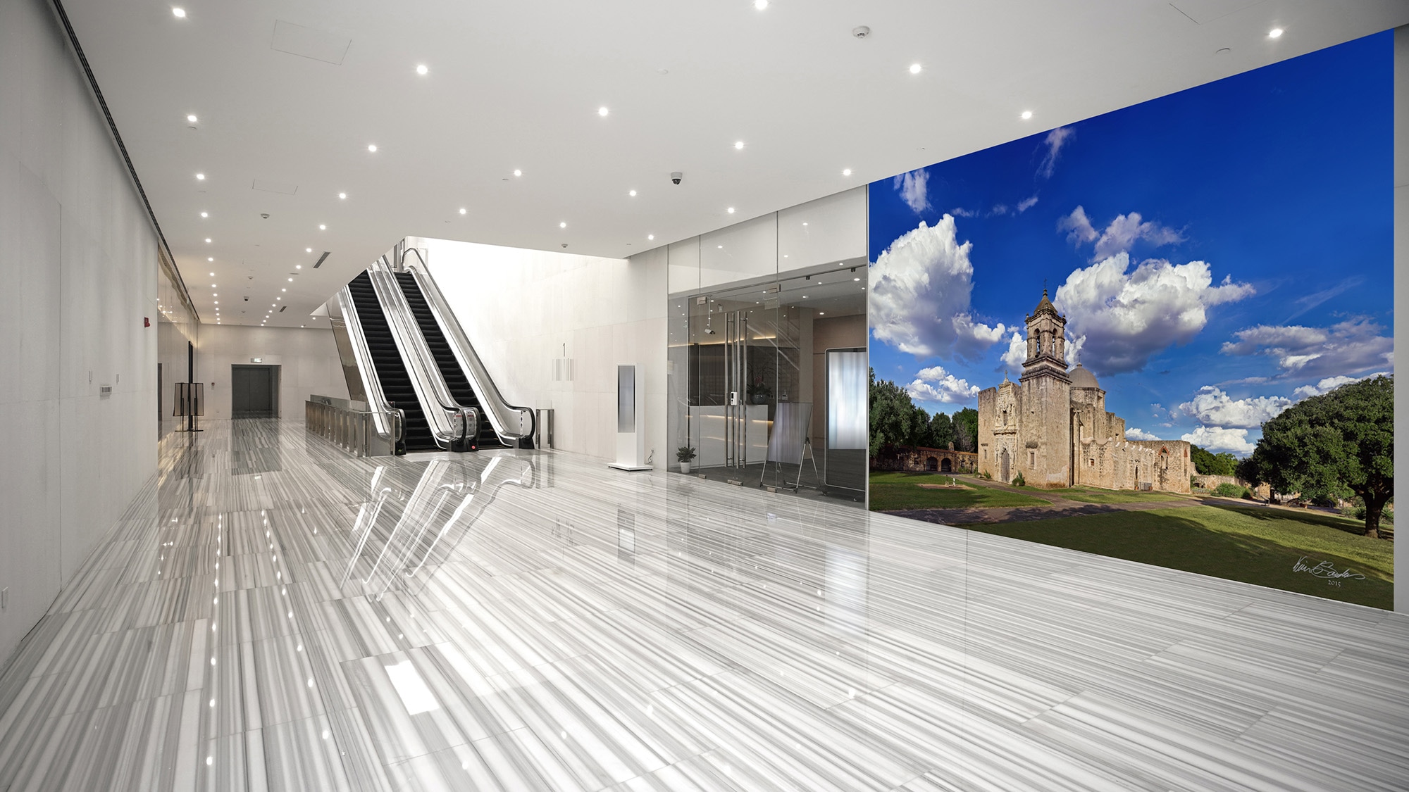 A grand-scale KGS Studios fine art piece of Mission San José, displayed as a mural in a modern, expansive corporate lobby.