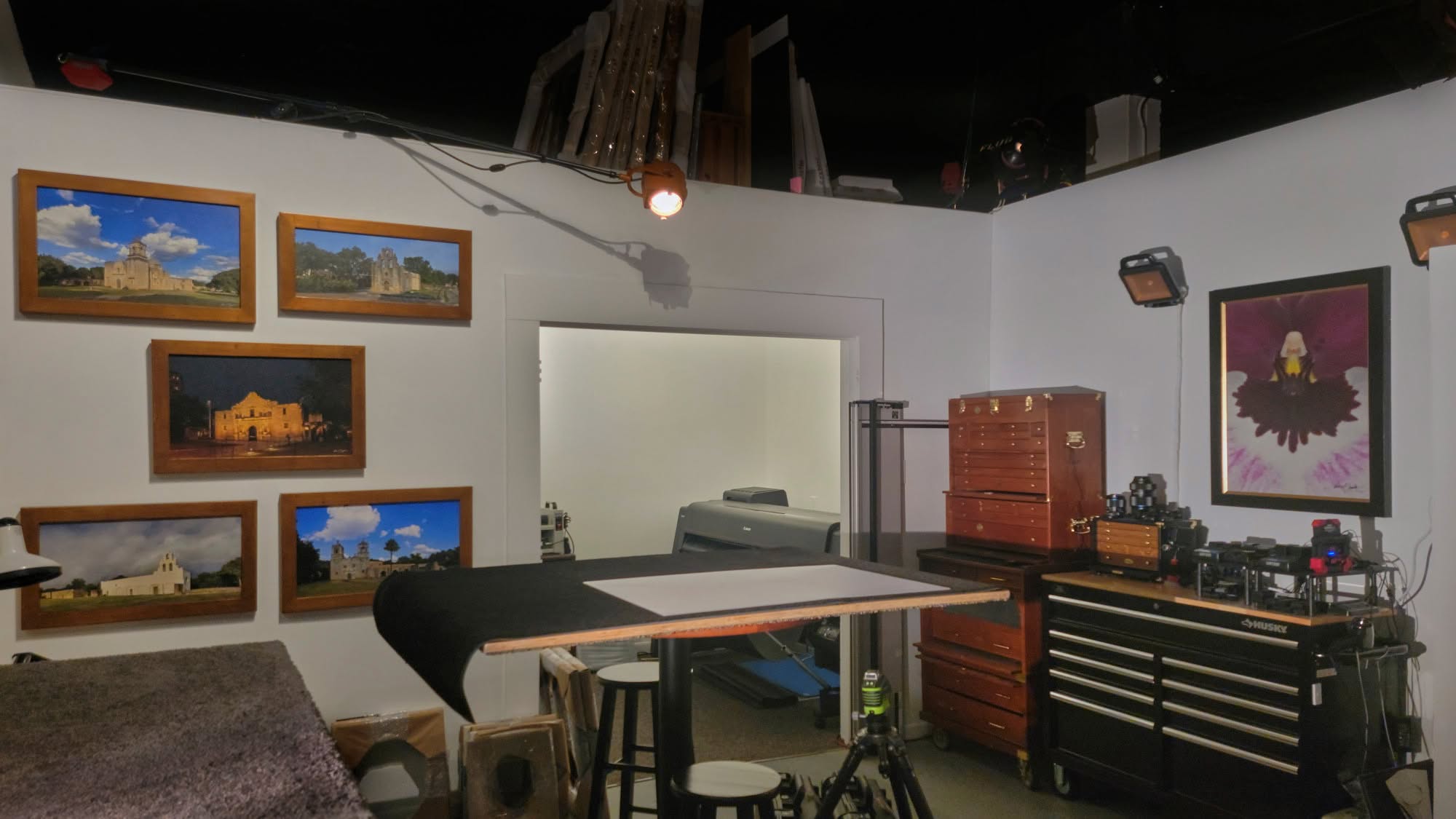 The in-house artist atelier at KGS Studios, showing the custom print framing and coating table, tool chests, and the World Heritage Missions Collection in "unlimited" scale.